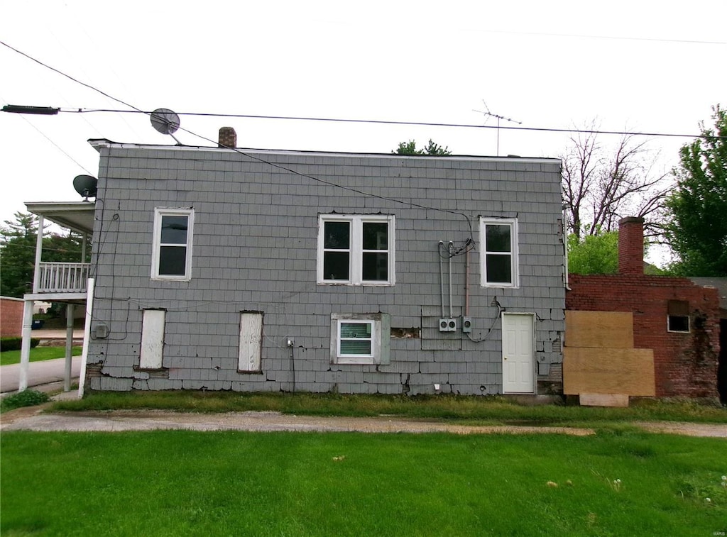 back of property featuring a yard and a chimney