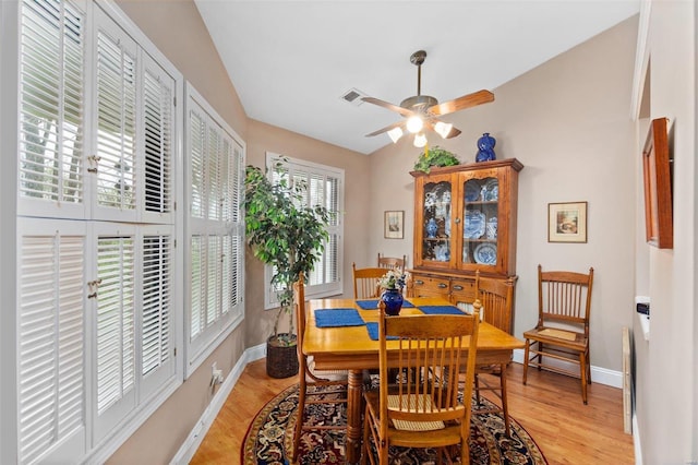 dining area with baseboards, light wood finished floors, ceiling fan, and visible vents
