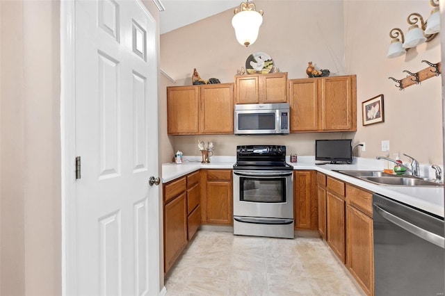 kitchen with a sink, brown cabinetry, light countertops, and appliances with stainless steel finishes