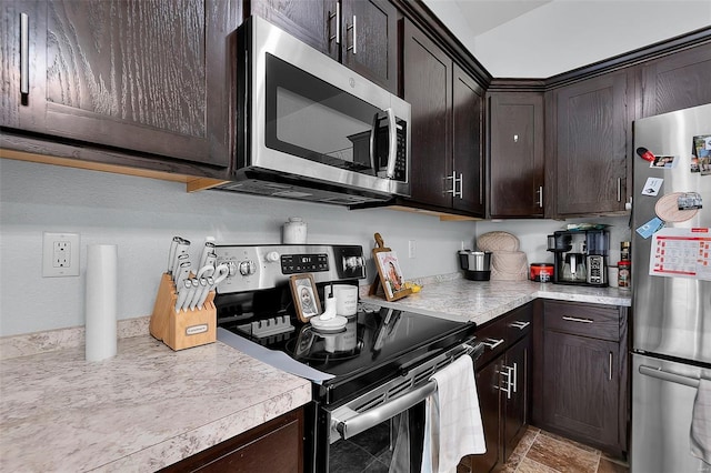 kitchen featuring stainless steel appliances, light countertops, and dark brown cabinets