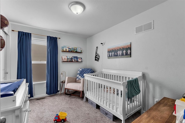 bedroom with a nursery area, visible vents, and carpet