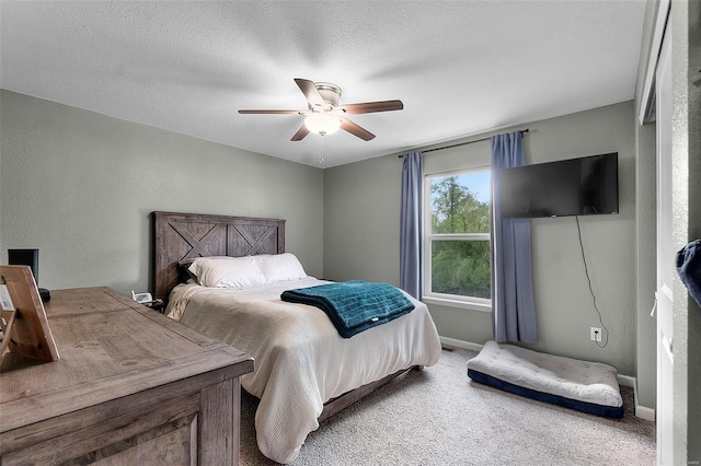 bedroom featuring ceiling fan, carpet flooring, baseboards, and a textured wall