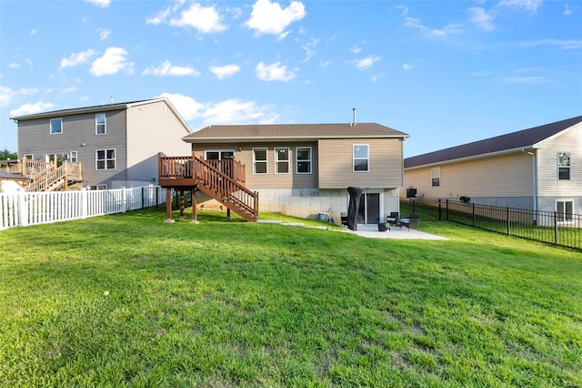 rear view of property featuring a yard, stairway, a wooden deck, and a fenced backyard
