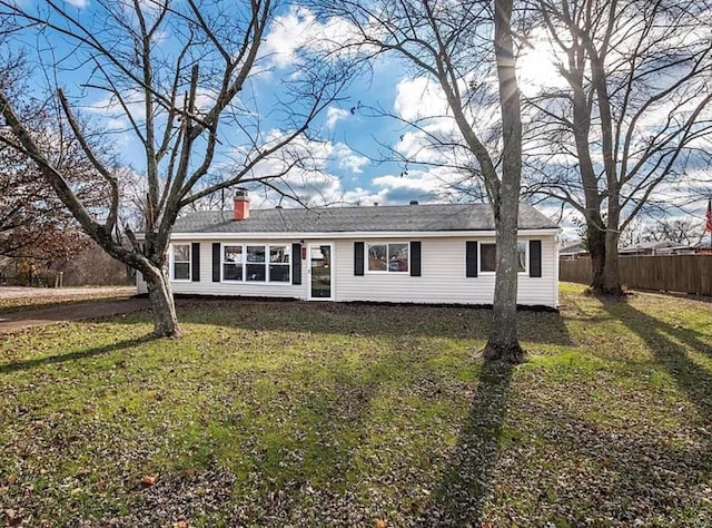 view of front of house with fence, a front lawn, and a chimney