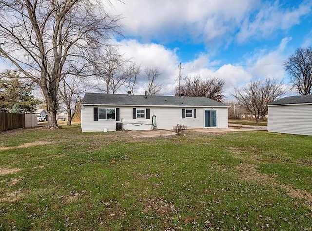 back of house featuring fence, a patio, and a lawn