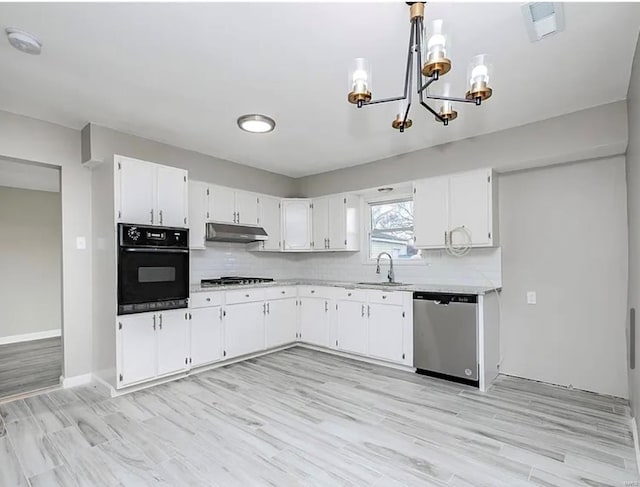 kitchen with light countertops, an inviting chandelier, appliances with stainless steel finishes, and under cabinet range hood