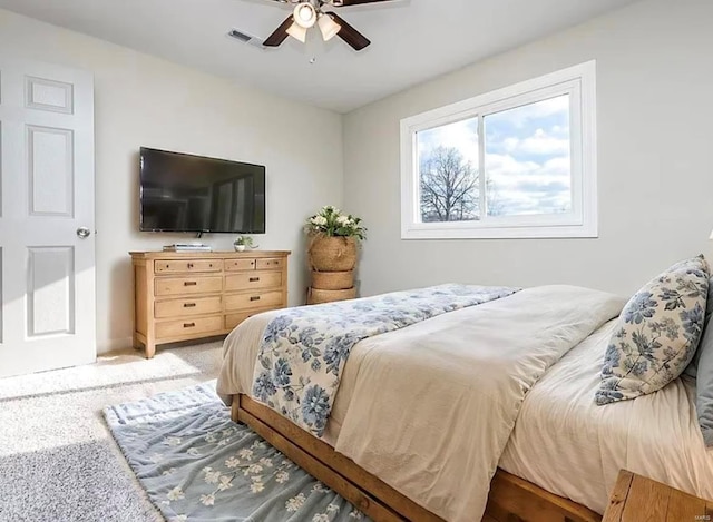 carpeted bedroom featuring a ceiling fan and visible vents