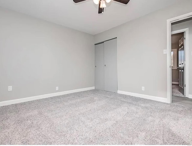 unfurnished bedroom with ceiling fan, carpet, a closet, and baseboards