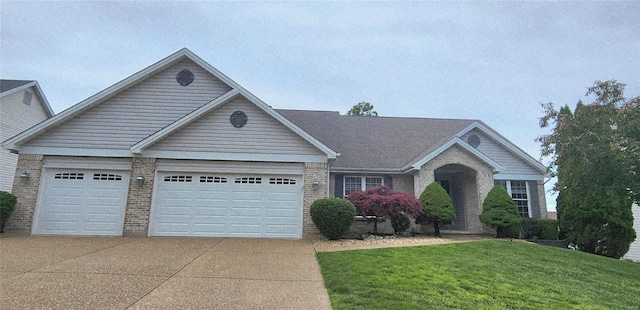 view of front of house with driveway, brick siding, a garage, and a front yard