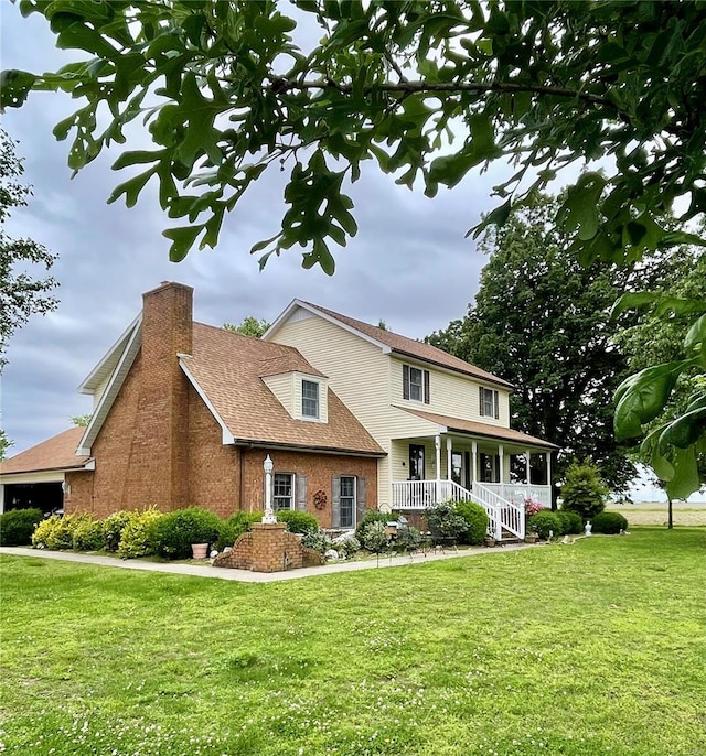 view of front facade with covered porch, brick siding, a chimney, and a front lawn