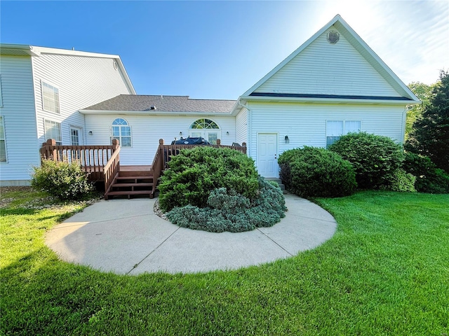 rear view of house featuring a yard and a wooden deck