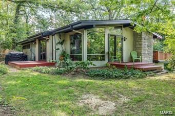 rear view of property with a wooden deck and a sunroom
