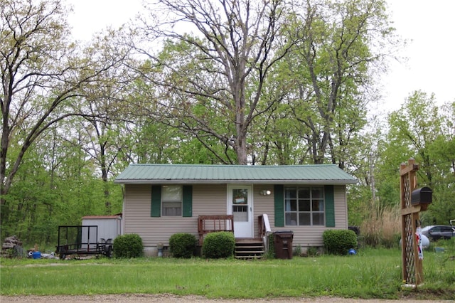 single story home with a front lawn and metal roof