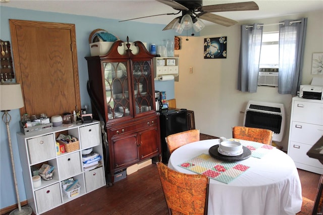 dining space featuring heating unit, dark wood-style flooring, a ceiling fan, and cooling unit