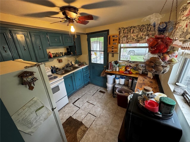 kitchen featuring a sink, white appliances, ceiling fan, light countertops, and light tile patterned floors