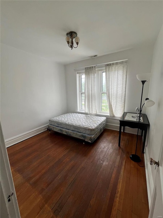 bedroom featuring dark wood finished floors and baseboards