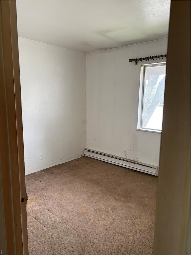 carpeted empty room featuring baseboard heating