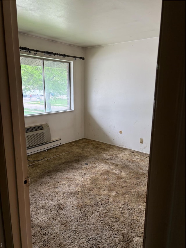 carpeted empty room featuring baseboard heating