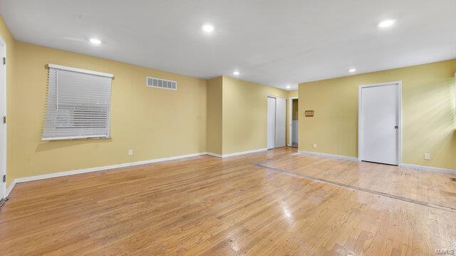 empty room with baseboards, recessed lighting, visible vents, and wood finished floors