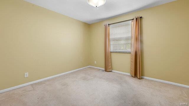 unfurnished room with carpet and baseboards
