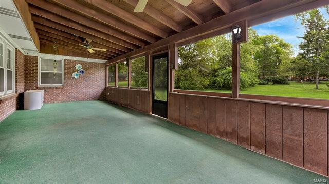 unfurnished sunroom featuring a ceiling fan and a wealth of natural light