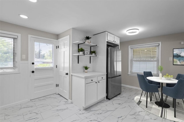kitchen with freestanding refrigerator, open shelves, wainscoting, marble finish floor, and recessed lighting