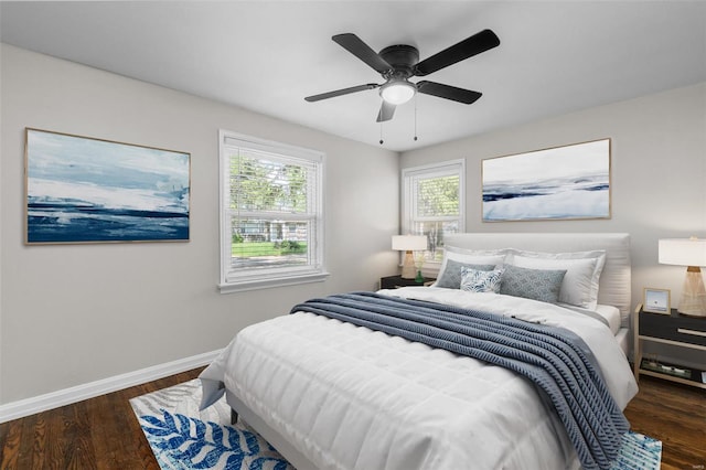 bedroom with multiple windows, wood finished floors, and baseboards