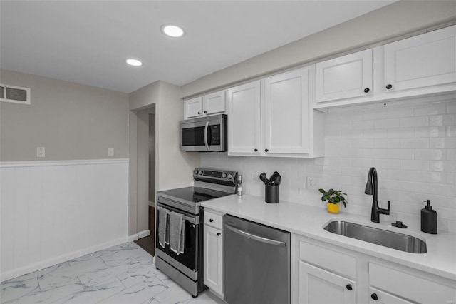 kitchen featuring marble finish floor, visible vents, a sink, white cabinetry, and appliances with stainless steel finishes