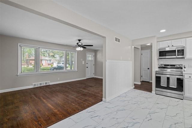 kitchen featuring appliances with stainless steel finishes, visible vents, marble finish floor, and a ceiling fan