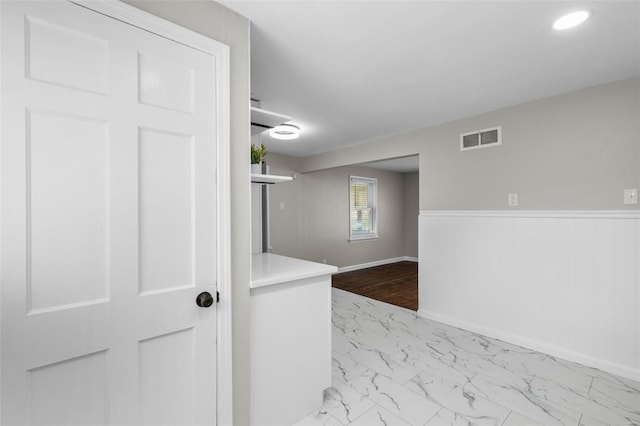 interior space featuring visible vents, baseboards, wainscoting, marble finish floor, and recessed lighting