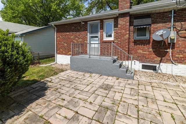 back of house with brick siding, a chimney, fence, and a patio area