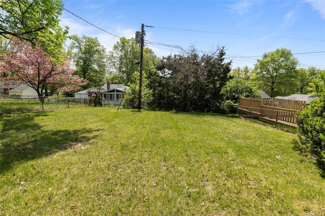 view of yard featuring a wooden deck and fence