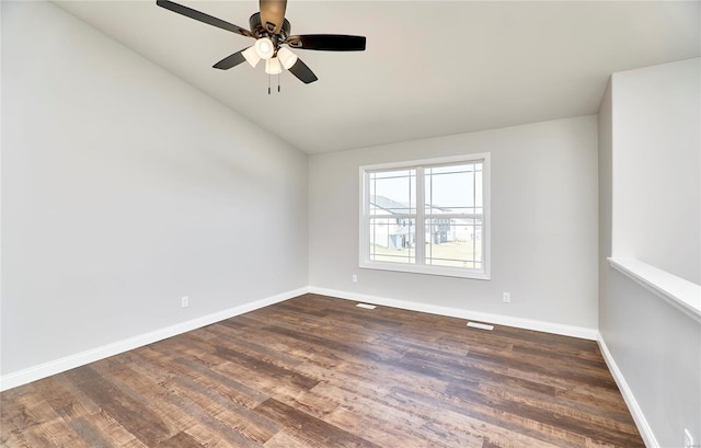 spare room with a ceiling fan, baseboards, lofted ceiling, and dark wood-style floors