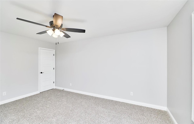 carpeted empty room featuring ceiling fan and baseboards