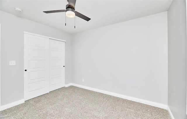 unfurnished bedroom with light colored carpet, a closet, baseboards, and ceiling fan