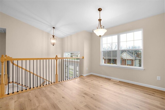 empty room featuring baseboards, visible vents, and wood finished floors