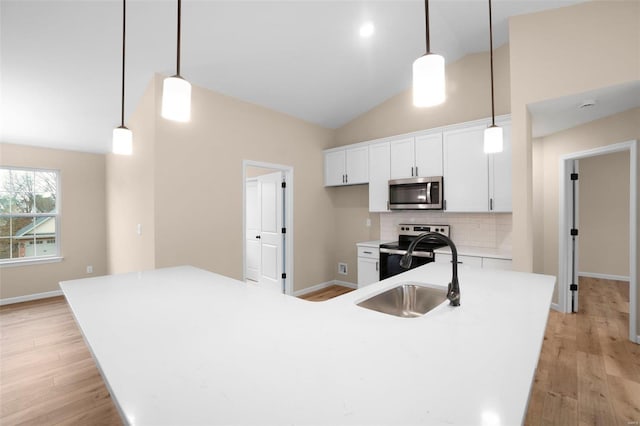 kitchen featuring light wood-style flooring, white cabinets, appliances with stainless steel finishes, and a sink