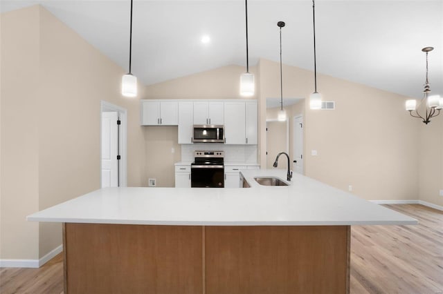 kitchen with baseboards, light wood finished floors, appliances with stainless steel finishes, and a sink