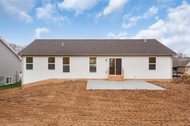 rear view of house with roof with shingles, a patio area, and entry steps