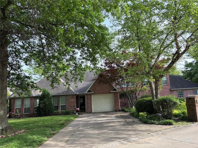 view of front of property with brick siding, an attached garage, concrete driveway, and a front yard