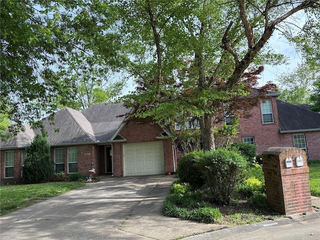 view of front facade featuring brick siding, concrete driveway, a garage, and a shingled roof