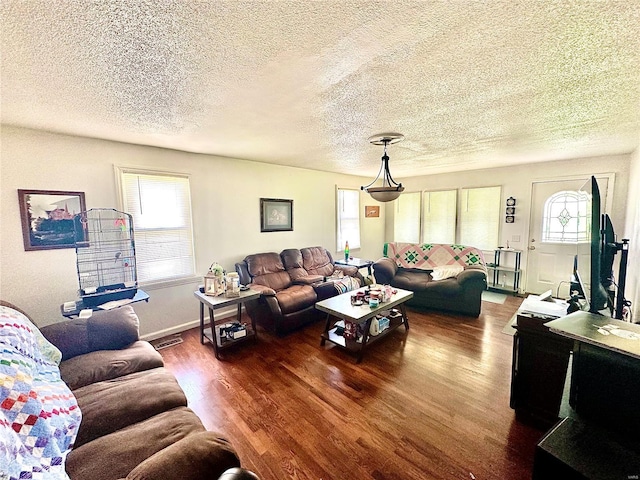 living area with a textured ceiling and wood finished floors