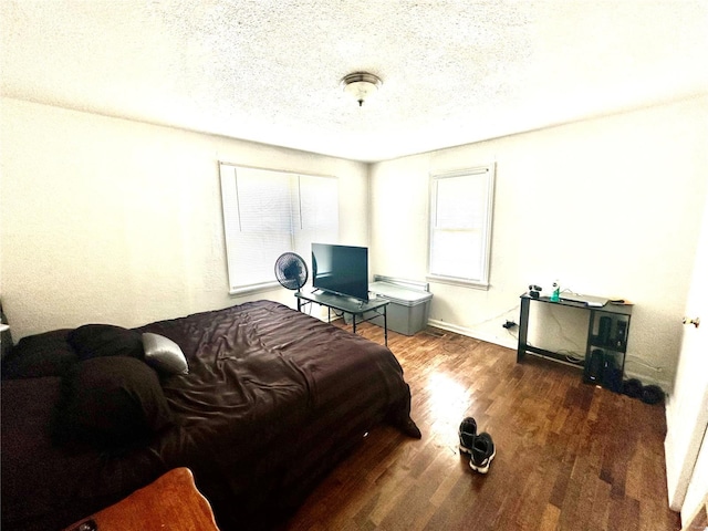bedroom with a textured ceiling and wood finished floors