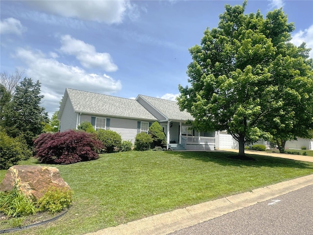 single story home featuring a porch, an attached garage, concrete driveway, a front lawn, and a shingled roof