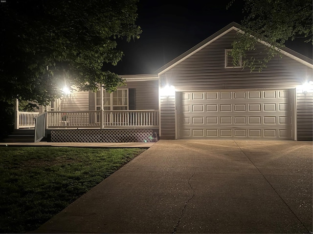 view of front of property featuring concrete driveway, covered porch, an attached garage, and a lawn