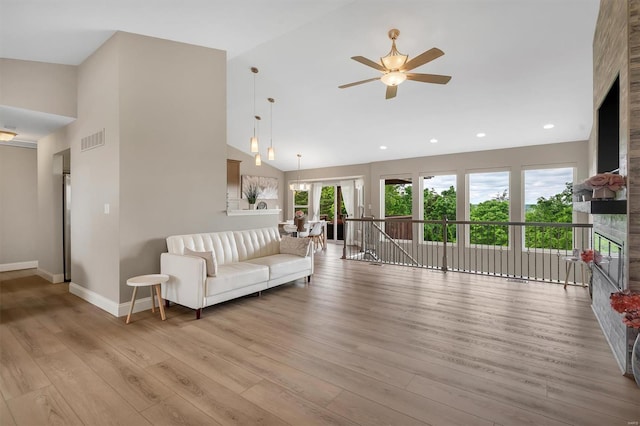 living area with baseboards, ceiling fan, visible vents, high vaulted ceiling, and wood finished floors