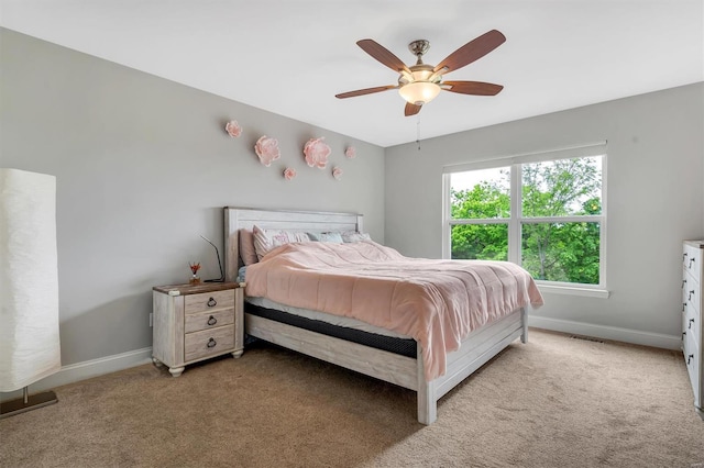 bedroom with baseboards, ceiling fan, visible vents, and light colored carpet