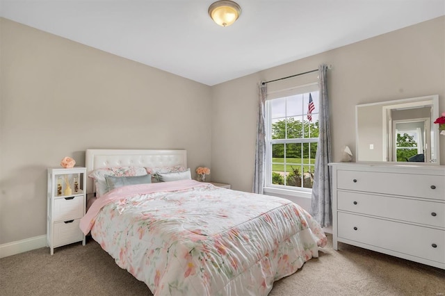 bedroom with light colored carpet and baseboards