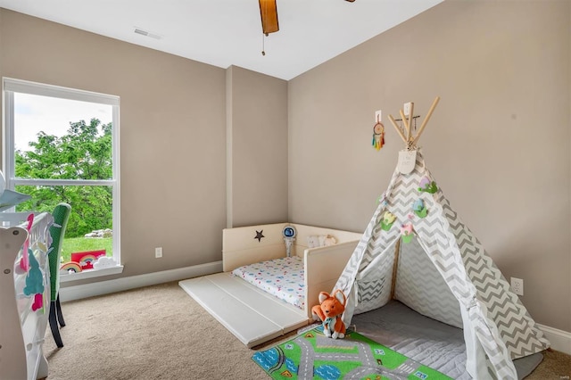 bedroom featuring baseboards, multiple windows, visible vents, and carpet