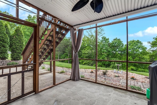 unfurnished sunroom featuring a ceiling fan